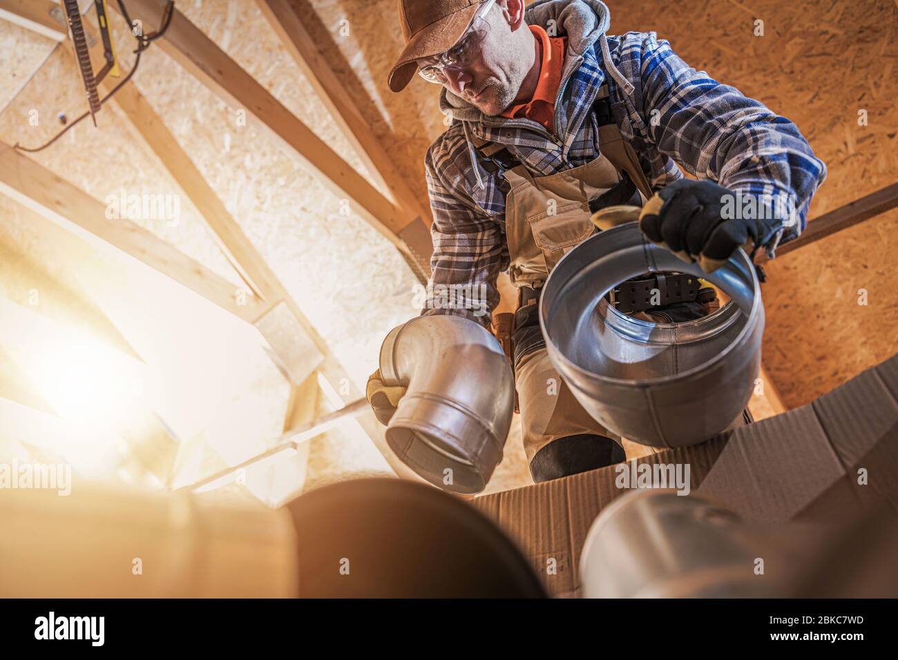 Tema industriale. Ventilazione dell'aria riscaldamento e raffreddamento operatore caucasico preparazione per il montaggio del sistema. Foto Stock