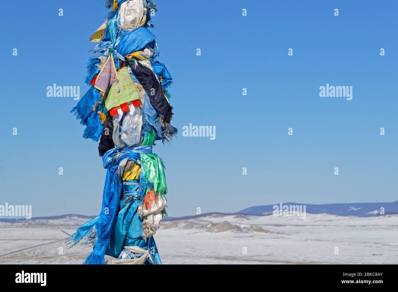 Bandiere nel vento. Gli Ovoo sono cumuli di pietra sacra usati come altari o santuari nelle pratiche religiose popolari mongolo. Foto Stock