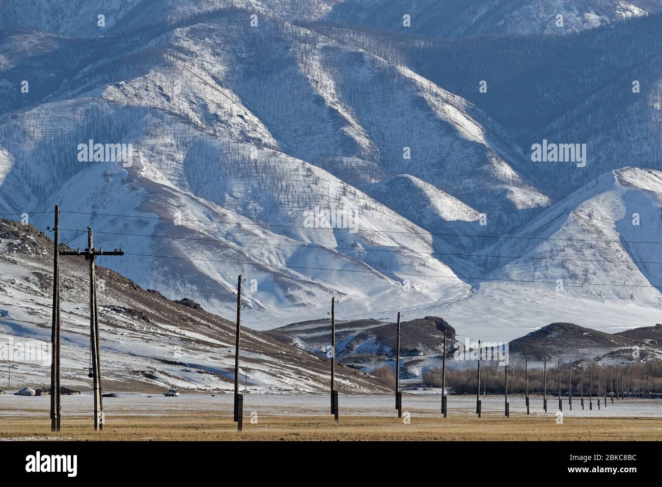 Una linea elettrica in un paesaggio invernale mongolo Foto Stock