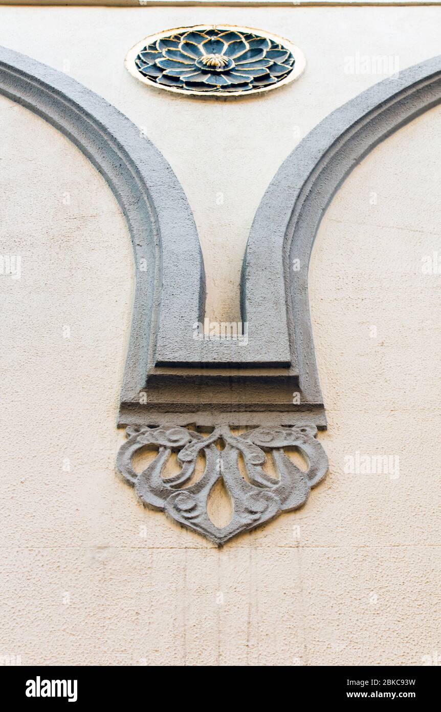 Primo piano di un esterno dell'epoca tardo ottomana elemento decorativo architettonico che incornicia una rosetta su sfondo di colore osseo. Foto Stock