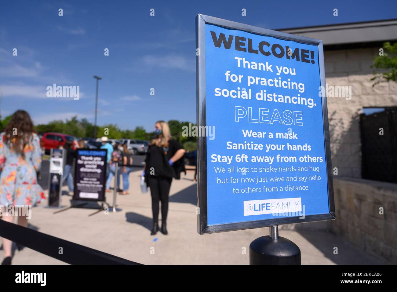 I fedeli che indossano maschere facciali arrivano all'ingresso della Chiesa di LifeAustin, mentre la congregazione ha tenuto servizi di persona per la prima volta in oltre sei settimane presso il suo teatro all'aperto da 1,500 posti a ovest di Austin il 3 maggio. I dirigenti della Chiesa hanno limitato il gruppo a 325 adoratori con biglietto, mentre richiedevano maschere e distanze sociali a causa della pandemia di coronavirus. Foto Stock