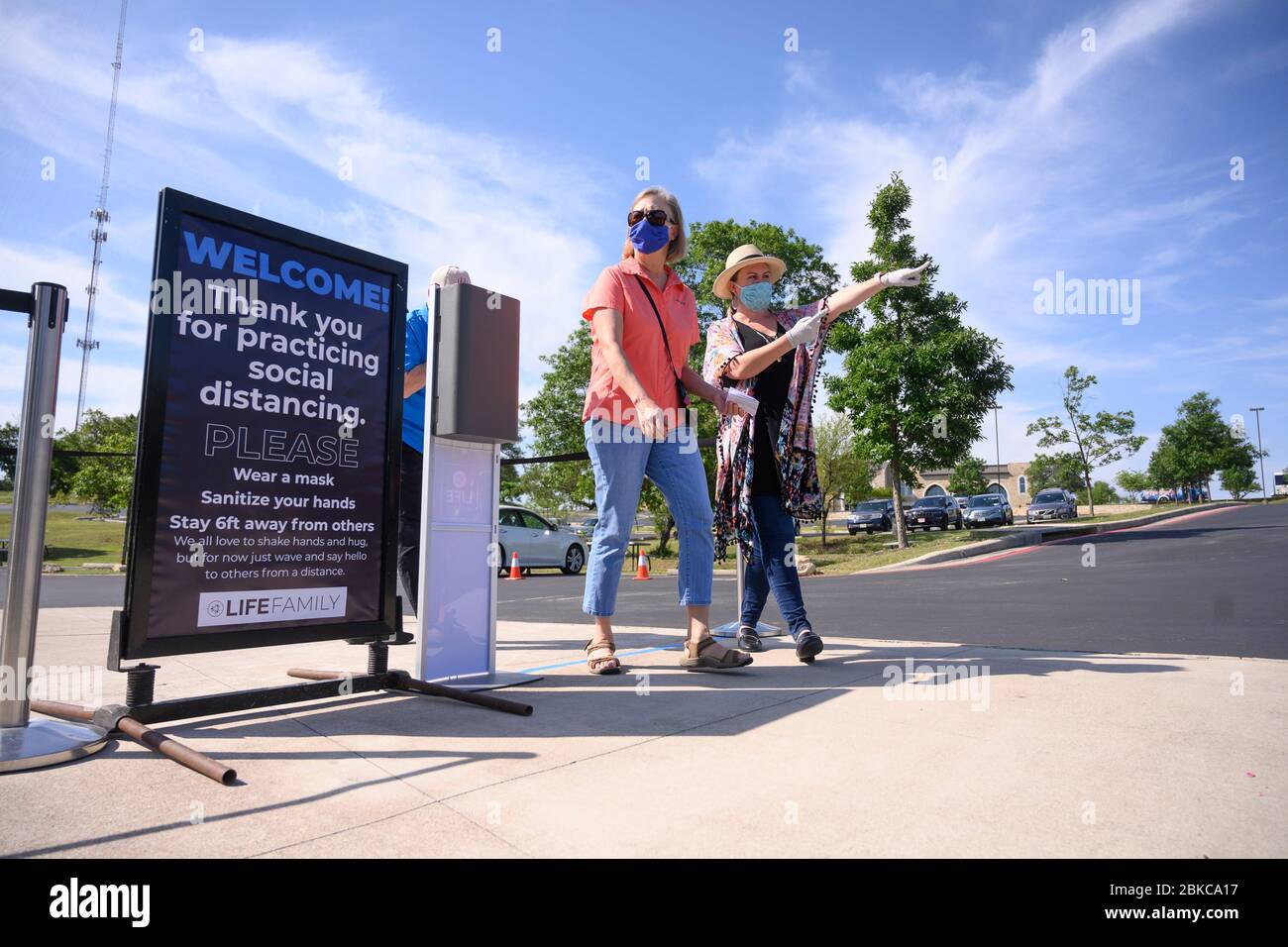 I fedeli che indossano maschere facciali arrivano all'ingresso della Chiesa di LifeAustin, mentre la congregazione ha tenuto servizi di persona per la prima volta in oltre sei settimane presso il suo teatro all'aperto da 1,500 posti a ovest di Austin il 3 maggio. I dirigenti della Chiesa hanno limitato il gruppo a 325 adoratori con biglietto, mentre richiedevano maschere e distanze sociali a causa della pandemia di coronavirus. Foto Stock