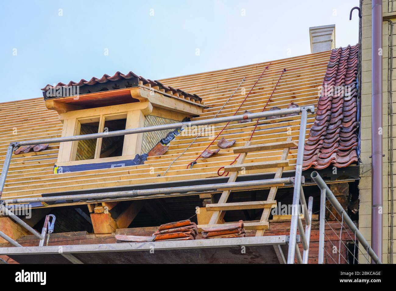 riparazione delle strutture del tetto di una storica casa in legno e sostituzione di piastrelle in argilla Foto Stock