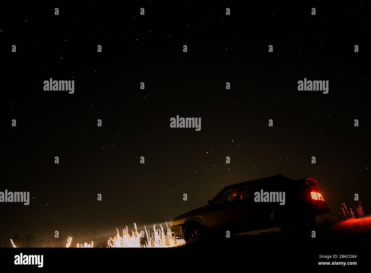 Auto con fari su sfondo stellato Foto Stock