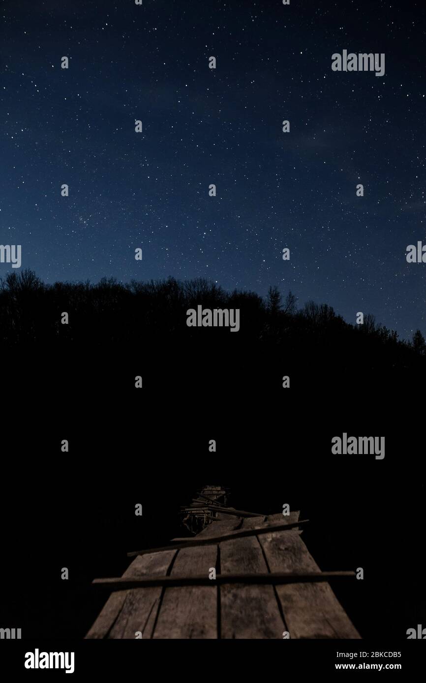 Passerella in legno sullo sfondo del cielo stellato Foto Stock