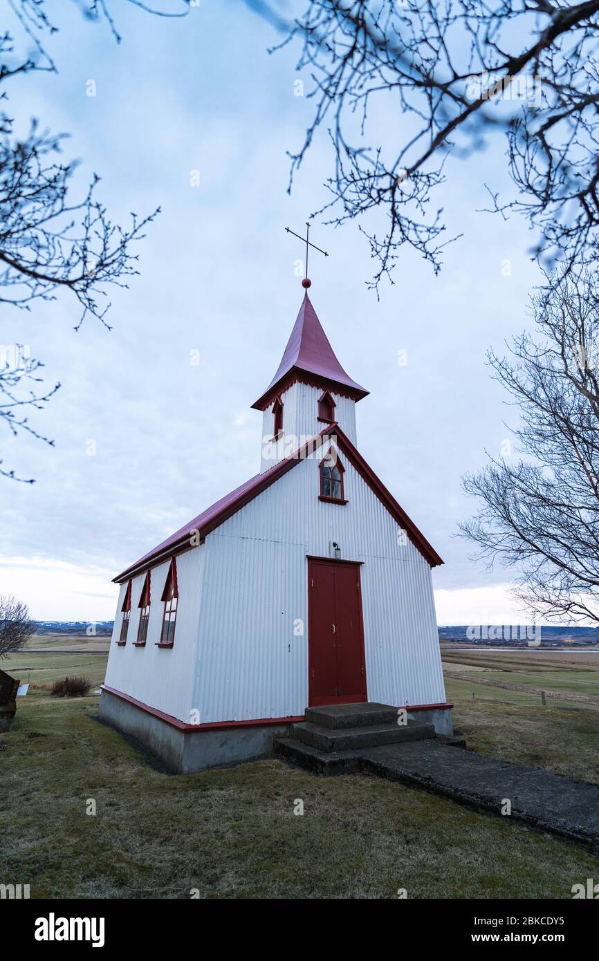 Tipica chiesa in legno di colore rosso nella città di Fludir, nel sud dell'Islanda, all'interno del cerchio d'oro. Foto di colore chiaro al tramonto Foto Stock
