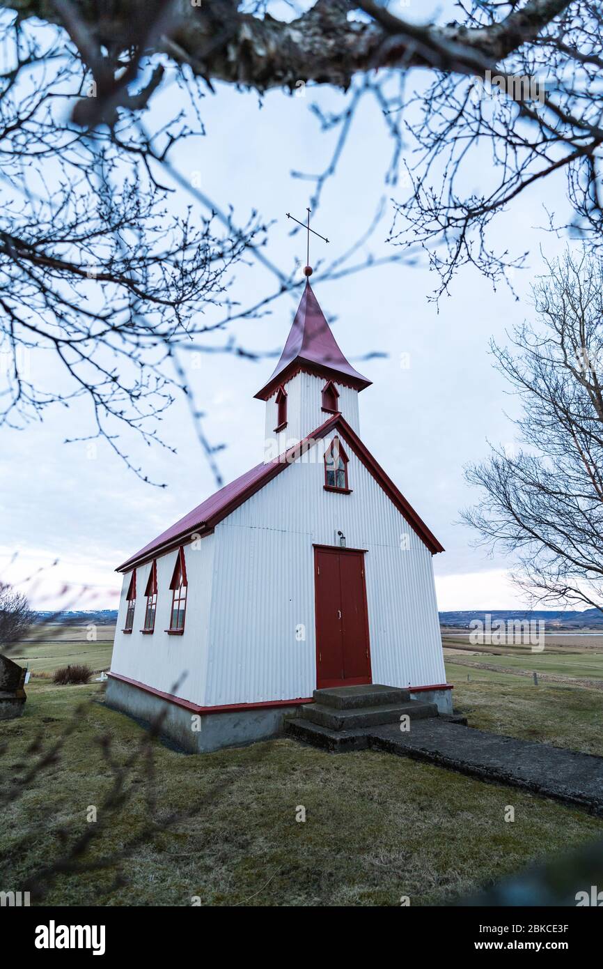 Tipica chiesa in legno di colore rosso nella città di Fludir, nel sud dell'Islanda, all'interno del cerchio d'oro. Foto di colore chiaro al tramonto Foto Stock