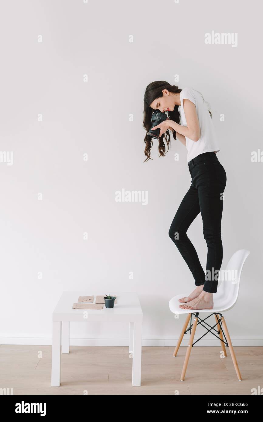 Giovane fotografo femminile, fotografare a casa. Foto Stock