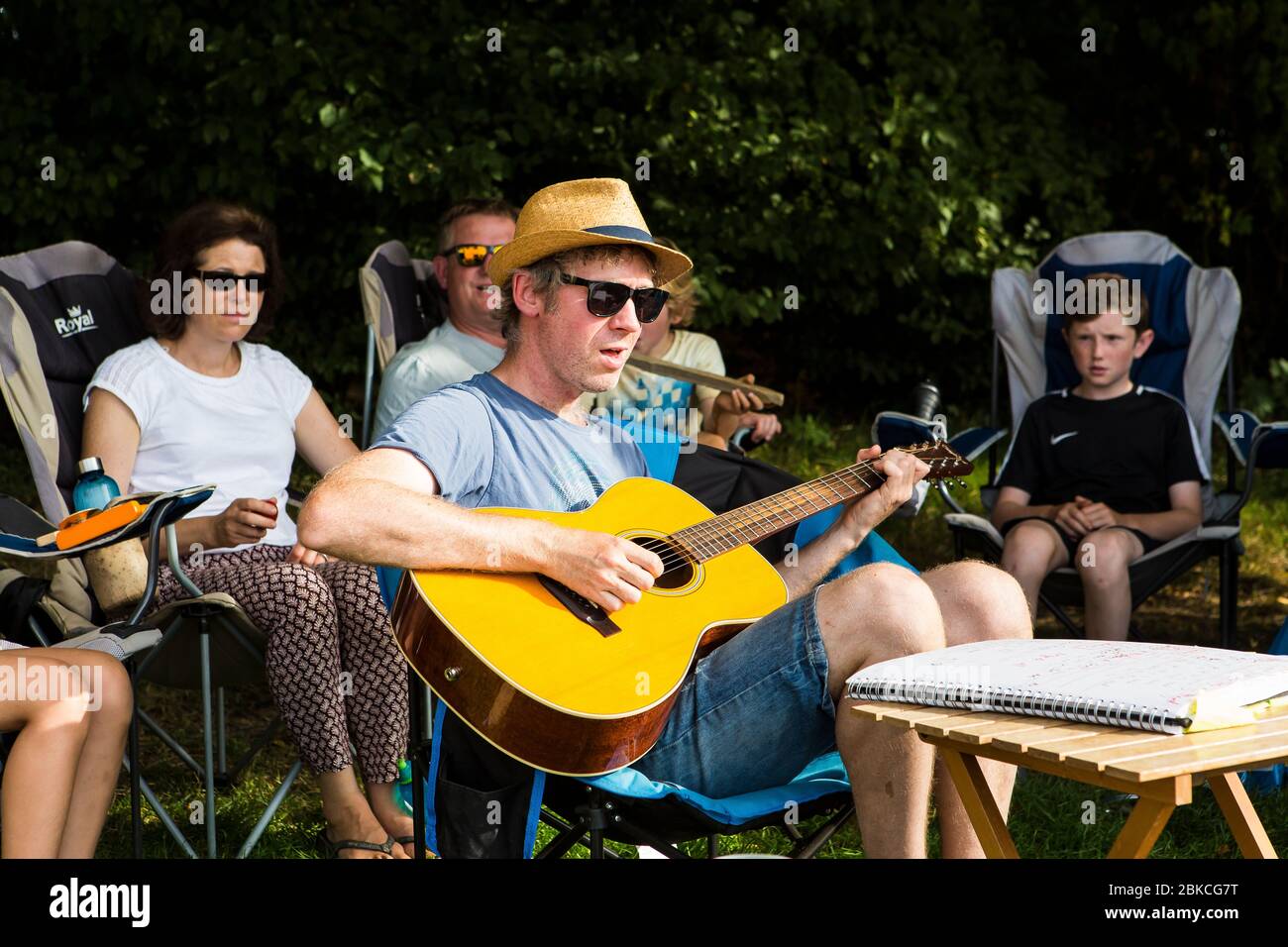 Canzoni di canto di famiglia con chitarra acustica in una vacanza estiva in campeggio a Wowo's, un campeggio di famiglia in Sussex Foto Stock