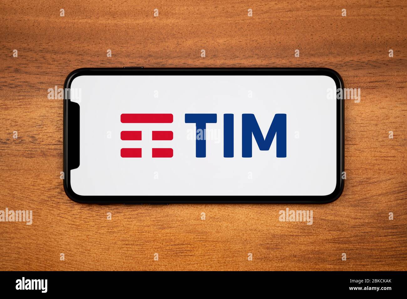Uno smartphone con il logo Telecom Italia (TIM) è appoggiato su un tavolo  di legno (solo per uso editoriale Foto stock - Alamy