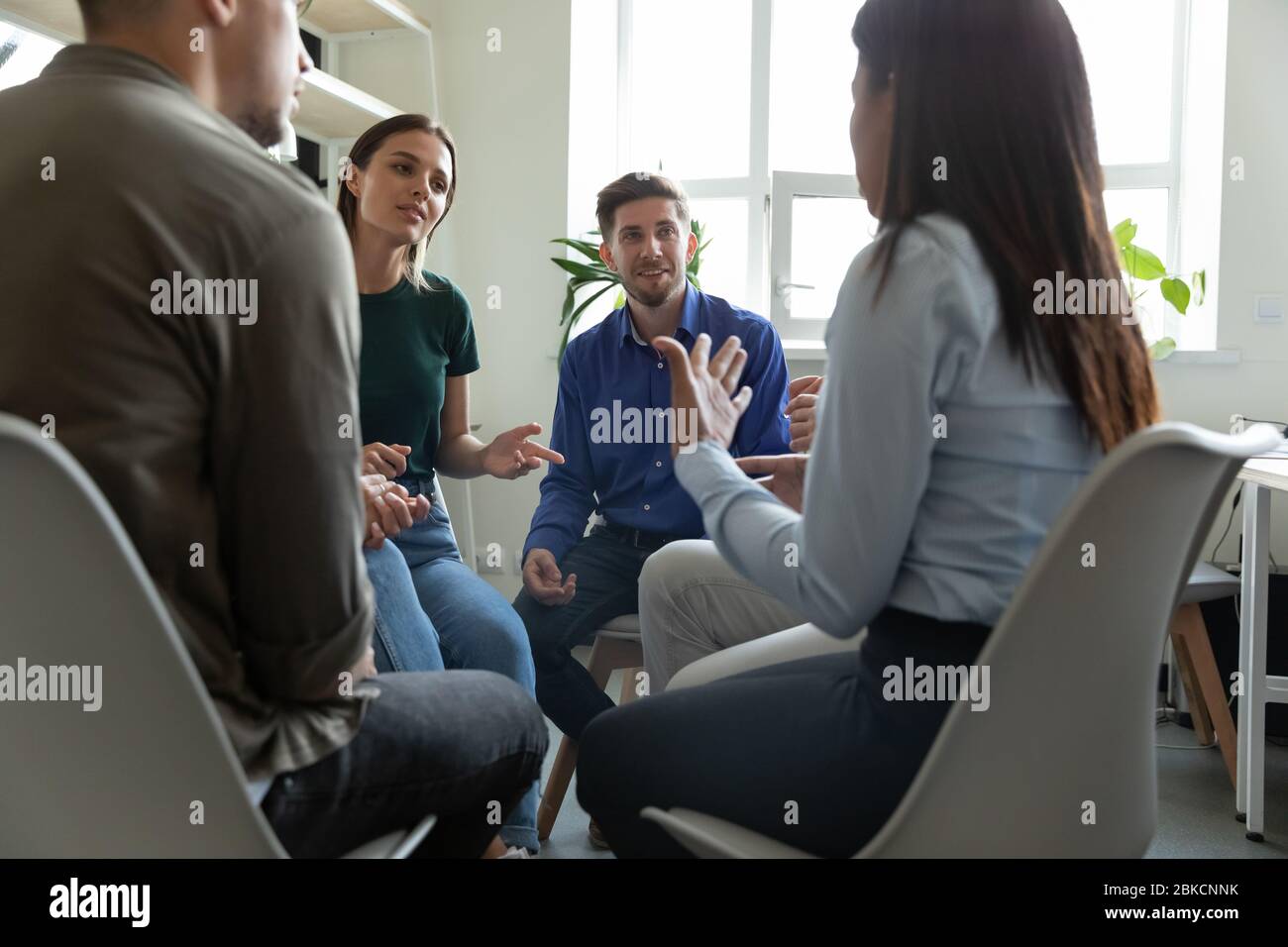 Un coach leader di sesso maschile sicuro che parla ascoltando il briefing dei dipendenti del team. Foto Stock
