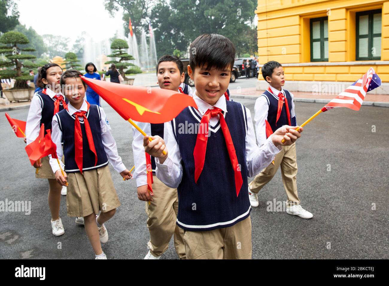 Il 27 febbraio 2019, il presidente Donald Trump è stato accolto da bambini che tenevano bandiere e guardie d'onore al Palazzo Presidenziale di Hanoi, in Vietnam, durante la sua visita ufficiale. La cerimonia faceva parte del suo viaggio diplomatico per rafforzare le relazioni USA-Vietnam. Foto Stock