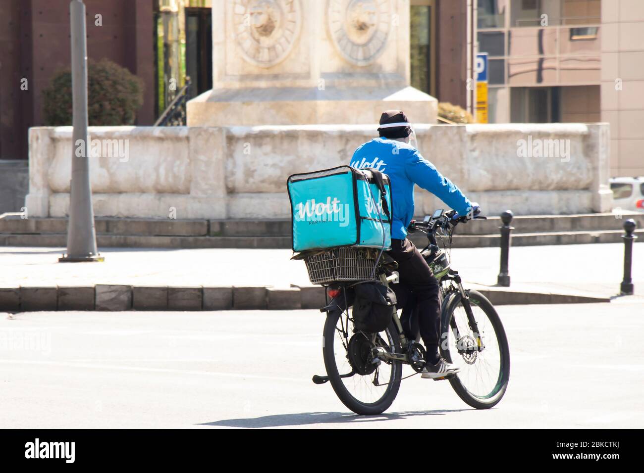 Belgrado, Serbia - 23 aprile 2020: Un corriere che lavora per il servizio di consegna di cibo Wolt a bordo di una bicicletta in città strada Foto Stock