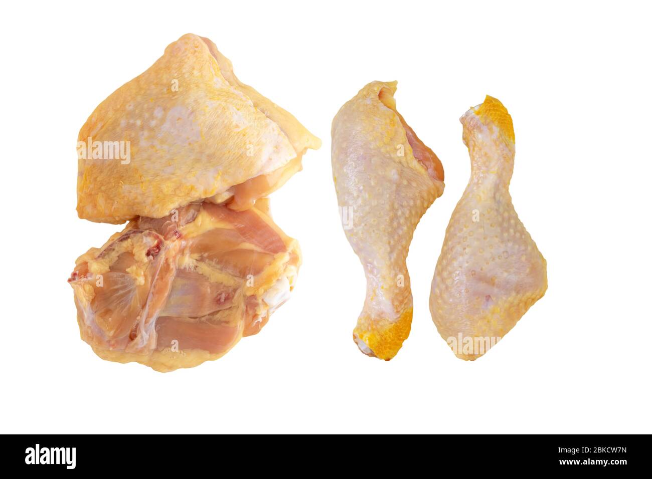 Mais giallo crudo alimentato cosce di pollo e cosce isolato su bianco. Foto Stock