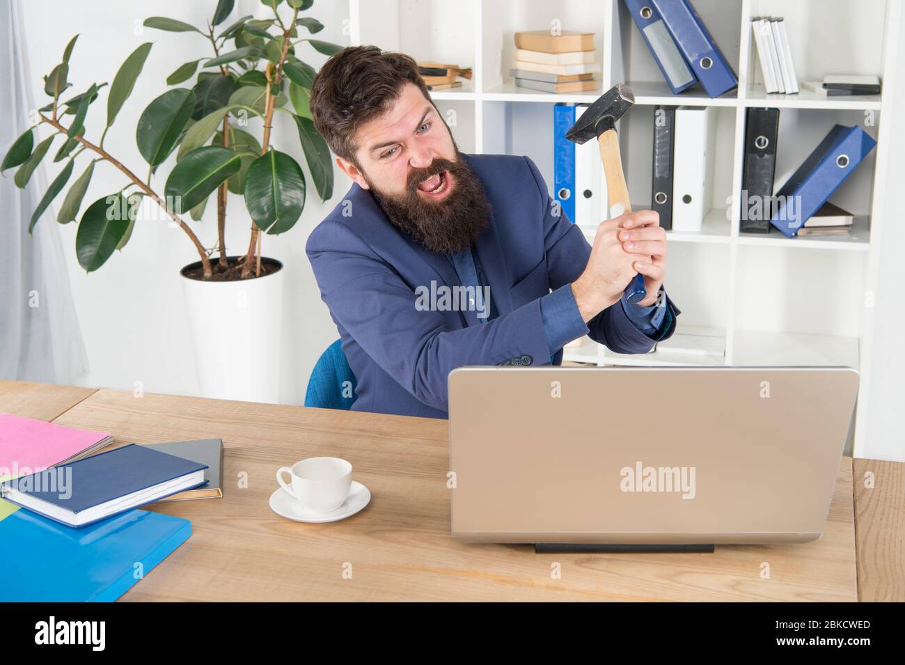 Urlare. Risolvere alcuni problemi aziendali. Virus di ritardo del calcolatore. Uomo d'affari arrabbiato o il responsabile con il muso. Uomo d'affari aggressivo in ufficio. Motivi per il ritardo del computer. Odio la routine dell'ufficio. Foto Stock