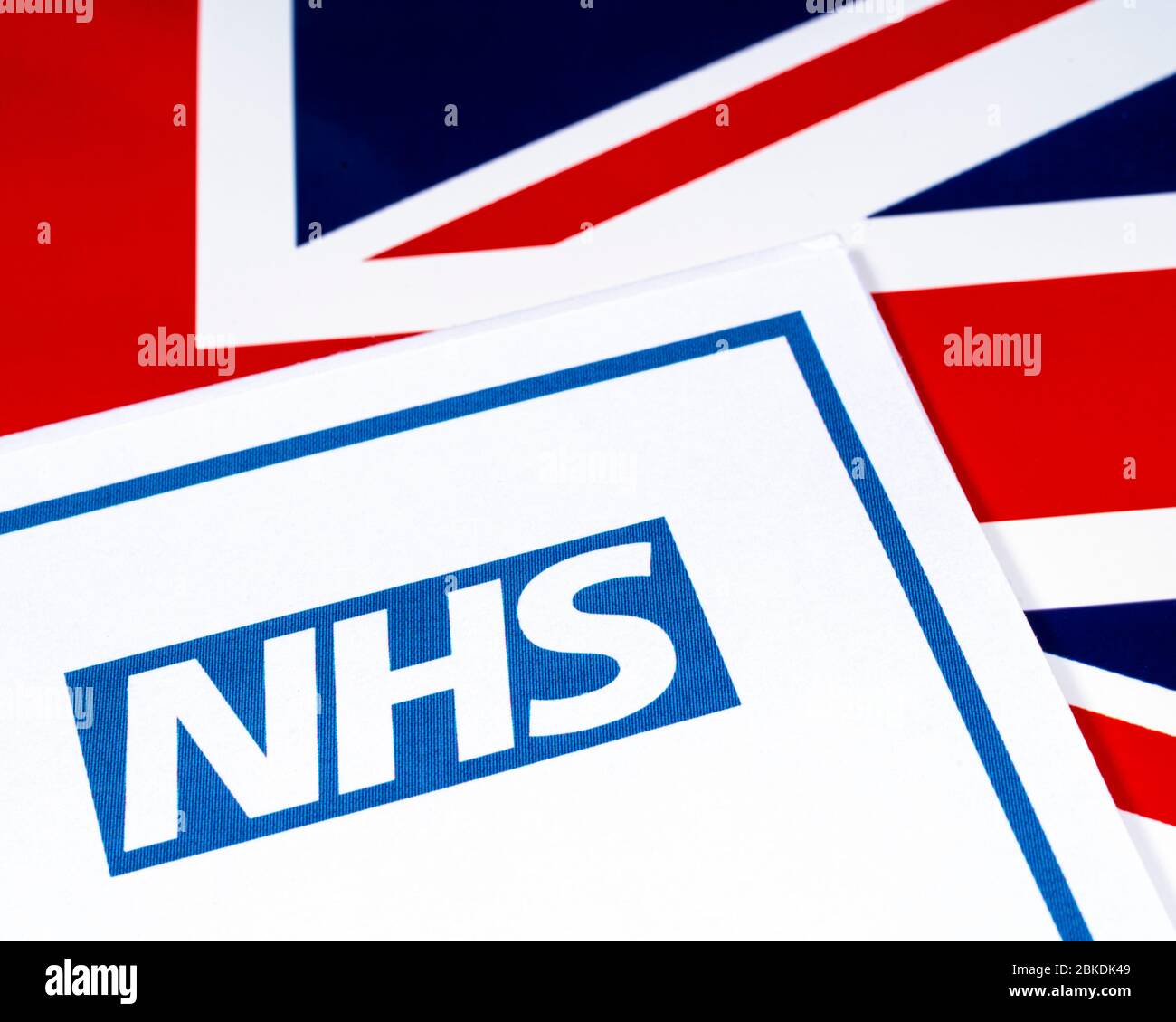 Londra, Regno Unito - 20 aprile 2020: Logo National Health Service, o NHS, con sfondo della bandiera britannica. Foto Stock