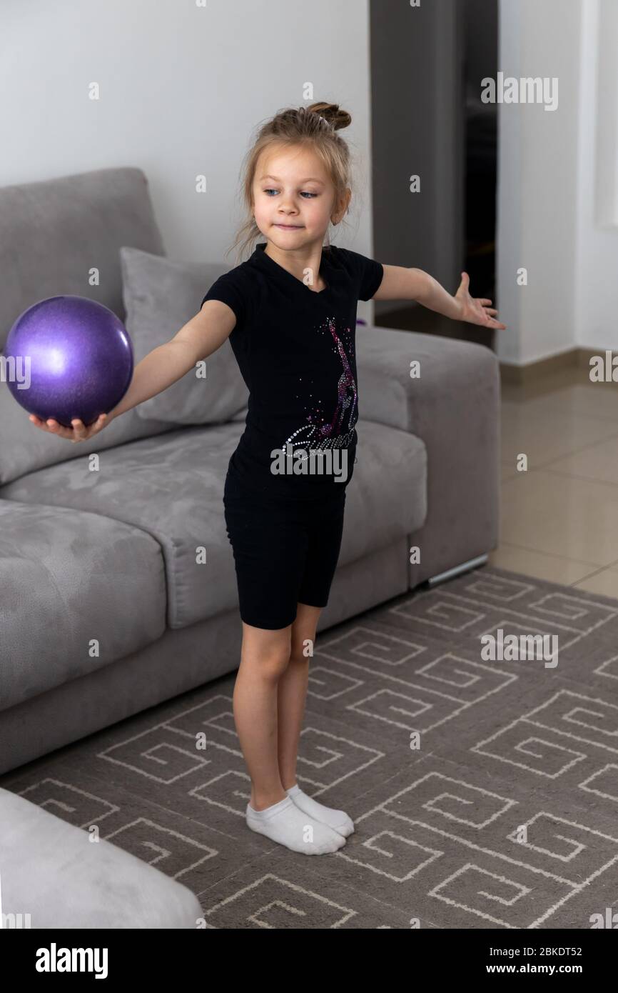 Ragazza ginnastica esegue esercizi con la palla. Sport per bambini, atletica, ginnastica ritmica Foto Stock