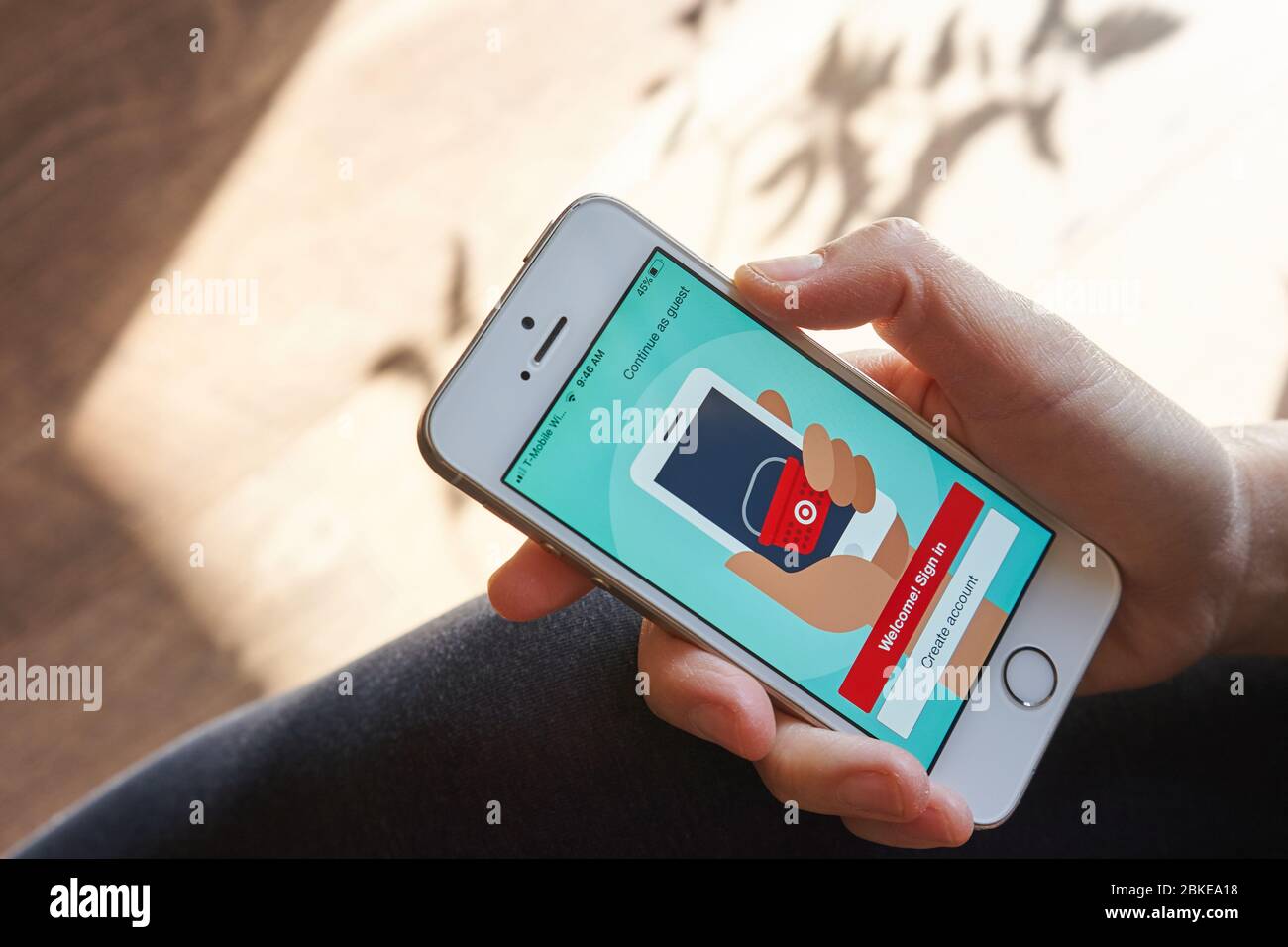 Una donna che usa l'app mobile Target dal suo telefono per fare acquisti online a casa. Foto Stock