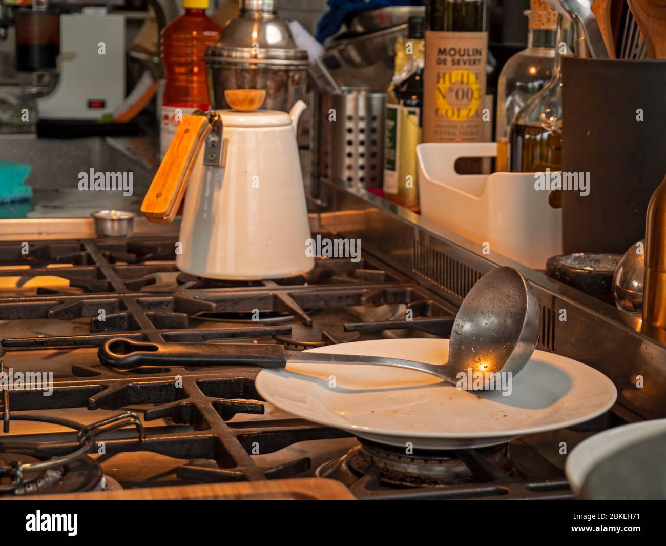 Una caraffa di acqua calda in una cucina rustica. Il jut si siede sulla parte superiore del forno con altri utensili da cucina intorno ad esso nella cucina moderna e rustica. Foto Stock