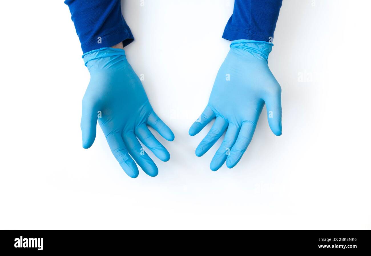Mani con guanti blu da vicino su sfondo bianco. Richiedere la disinfezione delle mani. Stop concetto di coronavirus. Uso di gel antibatterico per le mani durante Foto Stock