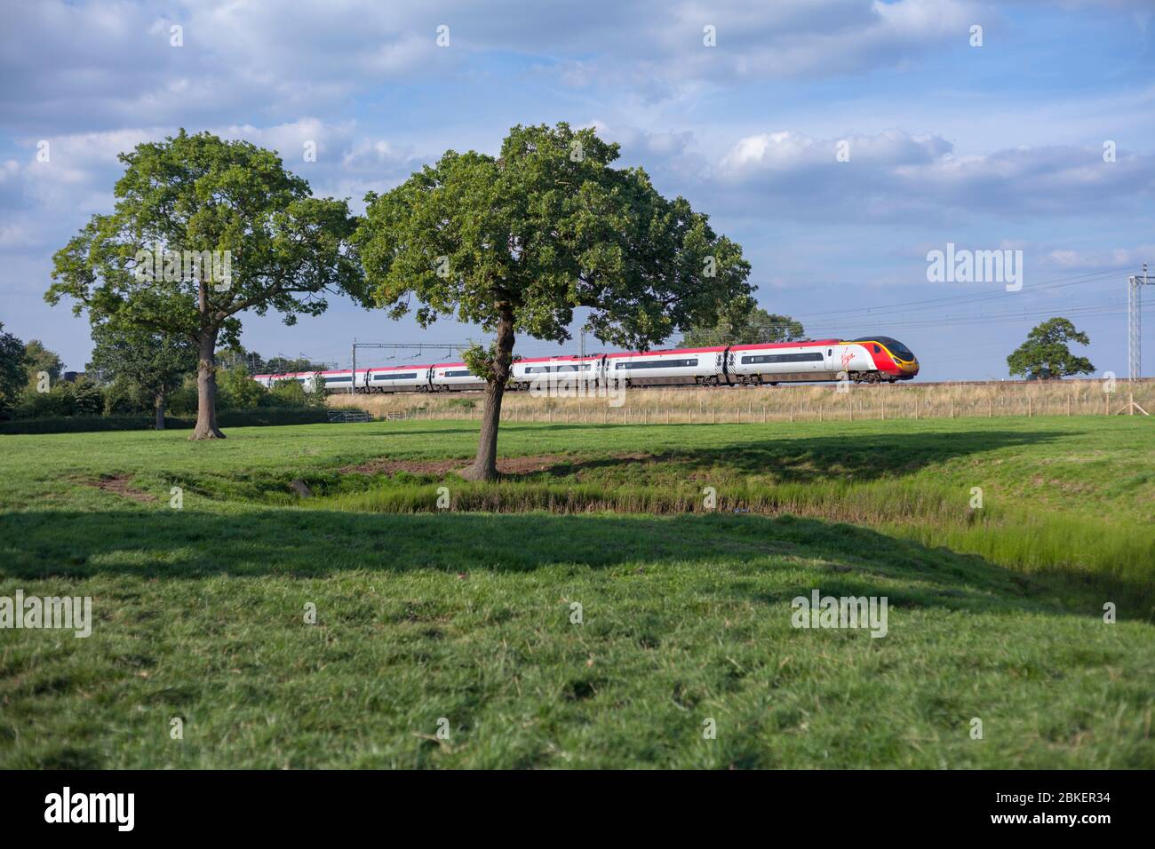 Virgin Trains Alstom pendolino treno che passa attraverso la campagna di Cheshire vicino a Winsford sulla linea principale della costa occidentale Foto Stock