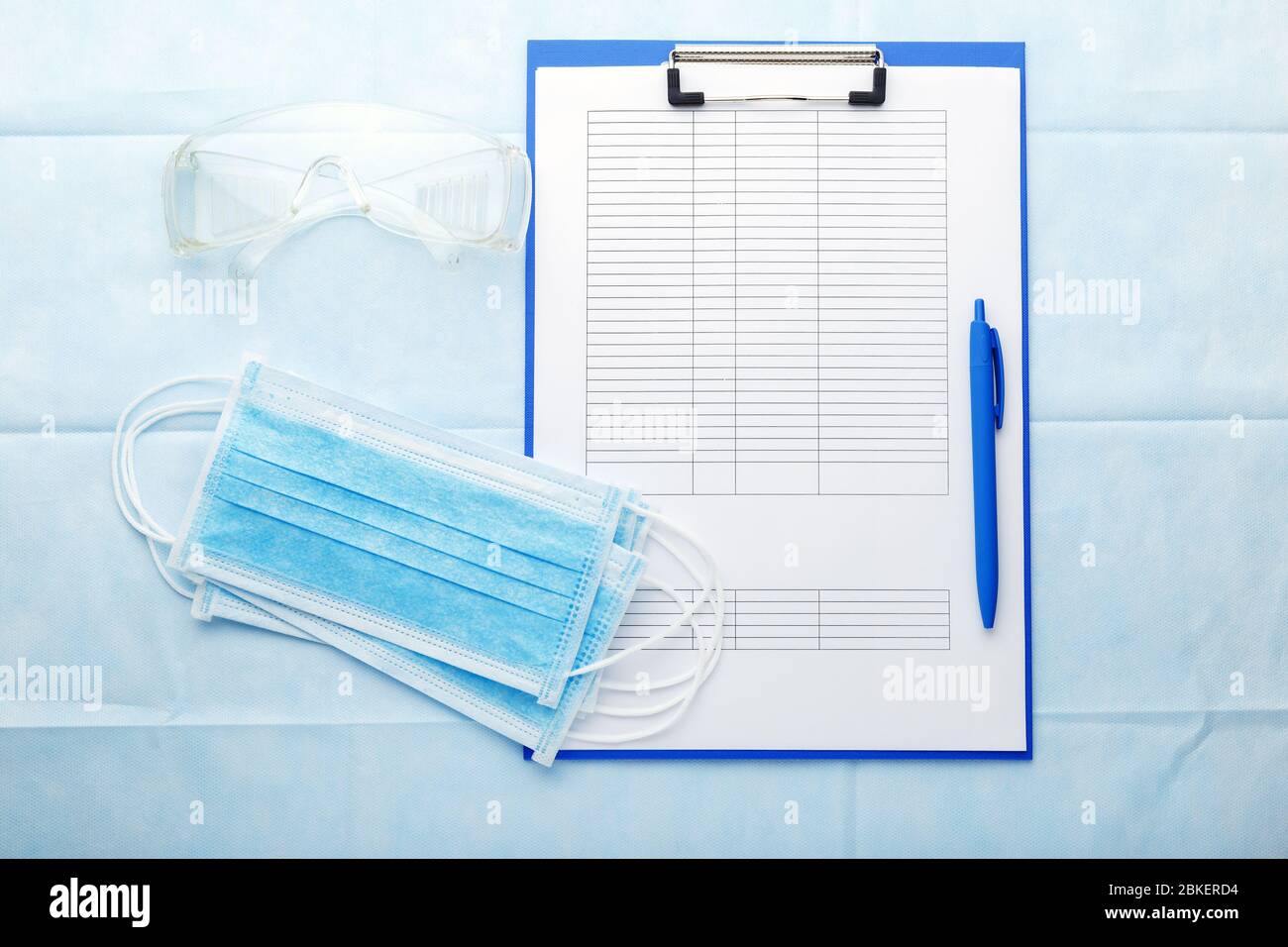 Prevenzione Coronovirus, modulo di analisi Covid-19. Maschera chirurgica facciale, documenti medici, occhiali protettivi sul posto di lavoro dei medici. Medico Foto Stock