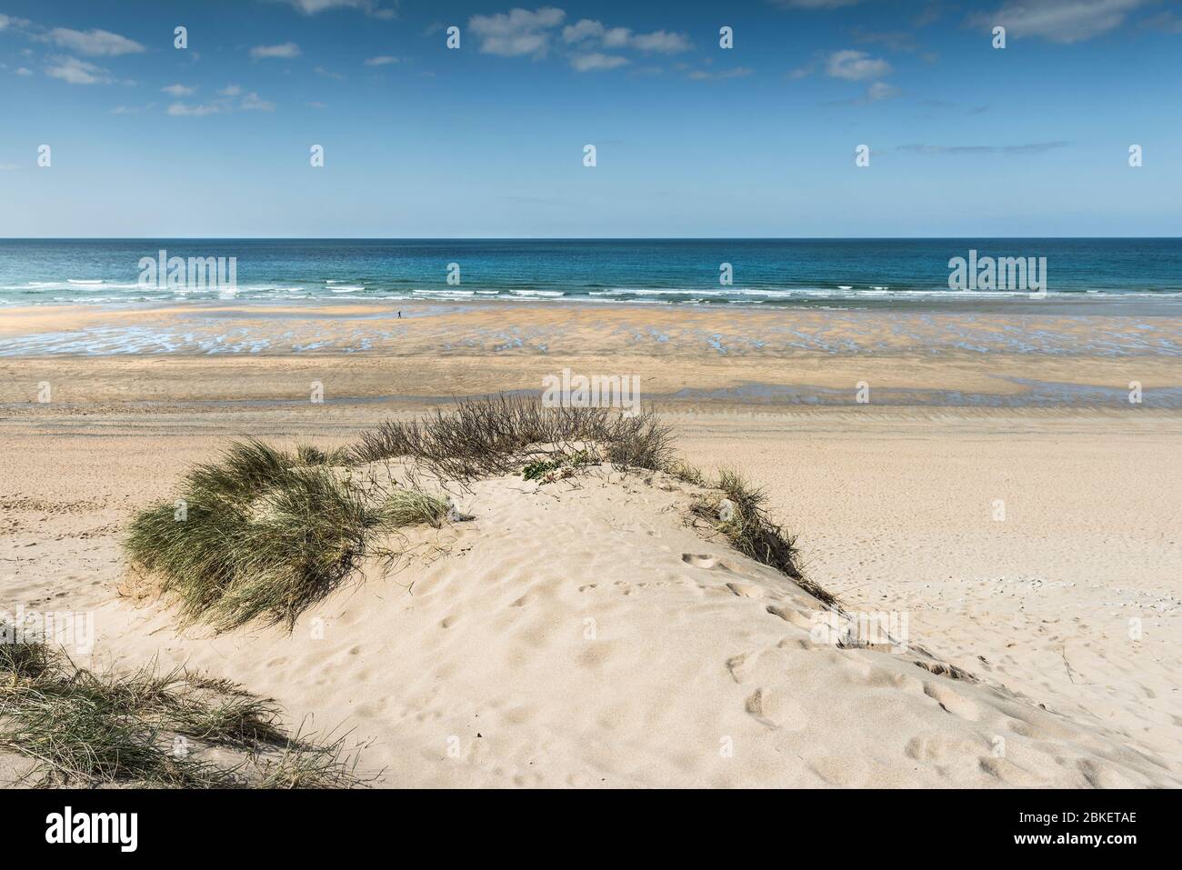 A causa del Coronavirus Covid-19 blocco Fistral Beach è deserta oltre alla piccola figura di una persona che si esercita a Newquay in Cornovaglia. Foto Stock