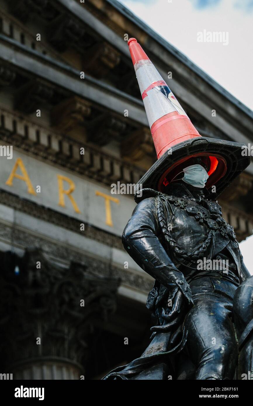 Statua del Duca di Wellington a Glasgow con cono di traffico sulla testa e maschera facciale del virus Corona. Foto Stock