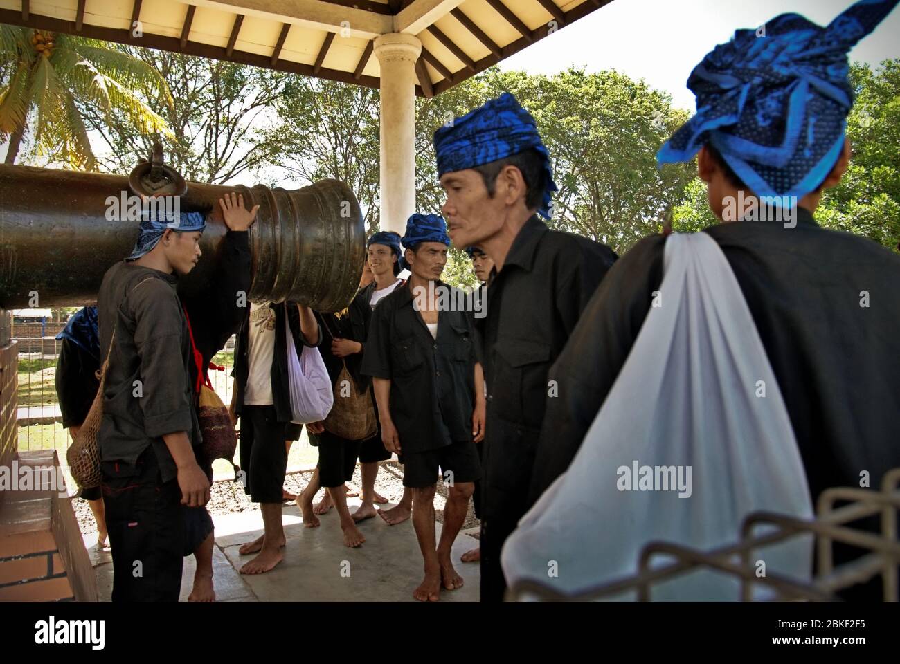 Uomini della tradizionale comunità "Urang Kanekes" - popolare conosciuta come il popolo Baduy --visitare un antico cannone tradizionalmente conosciuto come "Ki Amuk" nella storica zona di Old Banten. Old Banten, Serang regency, provincia di Banten, Indonesia. Foto: Reynold Sumayku Foto Stock