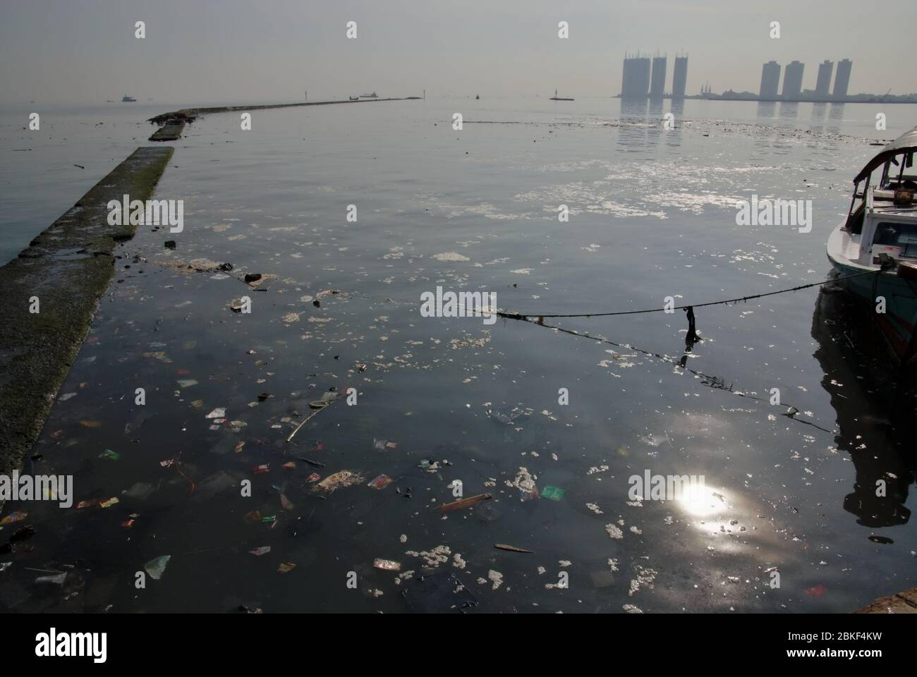 Inquinamento marino intorno alla struttura di frangiflutti a Muara Angke marina e porto di pesca a Penjaringan, Nord Jakarta, Indonesia. Foto Stock