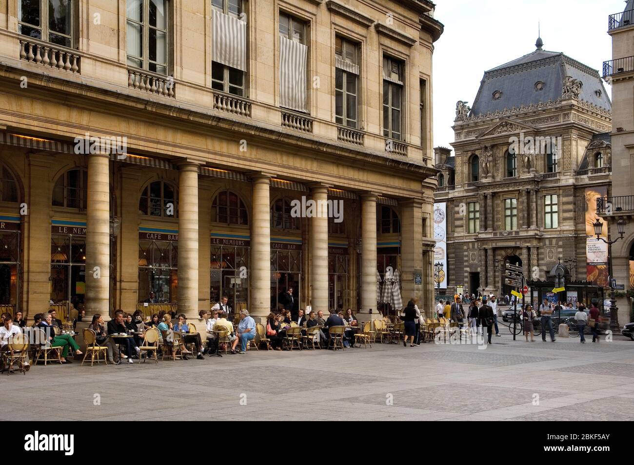 Persone al Cafe Bar Nemours con il Louvre sullo sfondo, Place Colette, Parigi, francia Foto Stock