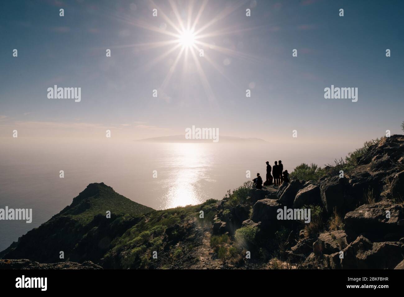 Giovane turista felice sulla cima di una montagna godendo di vista mare prima del tramonto Foto Stock