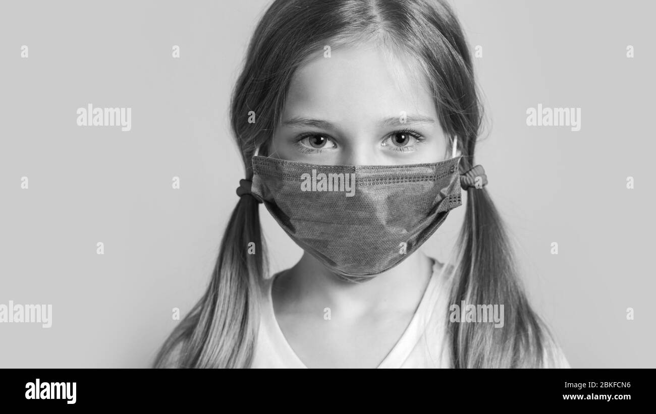 Little Kid utilizza una maschera medica o chirurgica per proteggerla da virus, malattia, Covit-19 e infezione da coronavirus Foto Stock