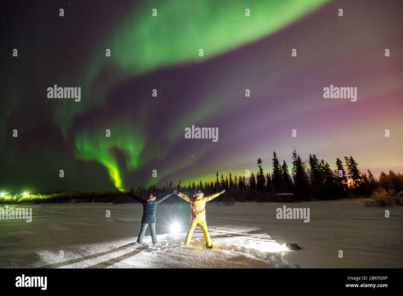 Due persone Traveler in proiettore luminoso su sfondo iridescente cielo. Effetto sfocatura soft focus Foto Stock