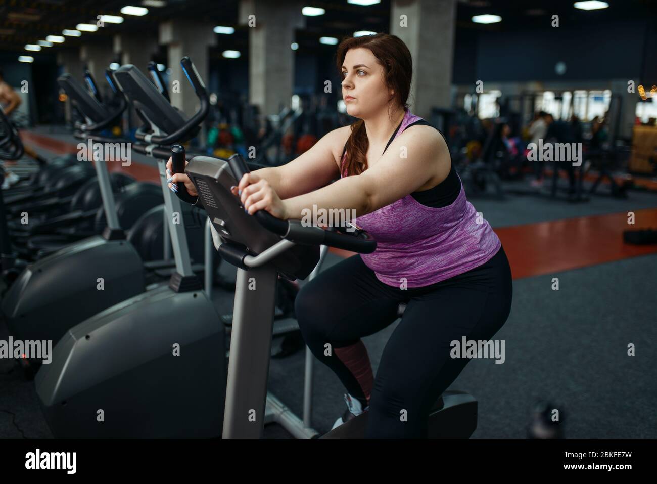 Donna in sovrappeso si allena in palestra Foto Stock