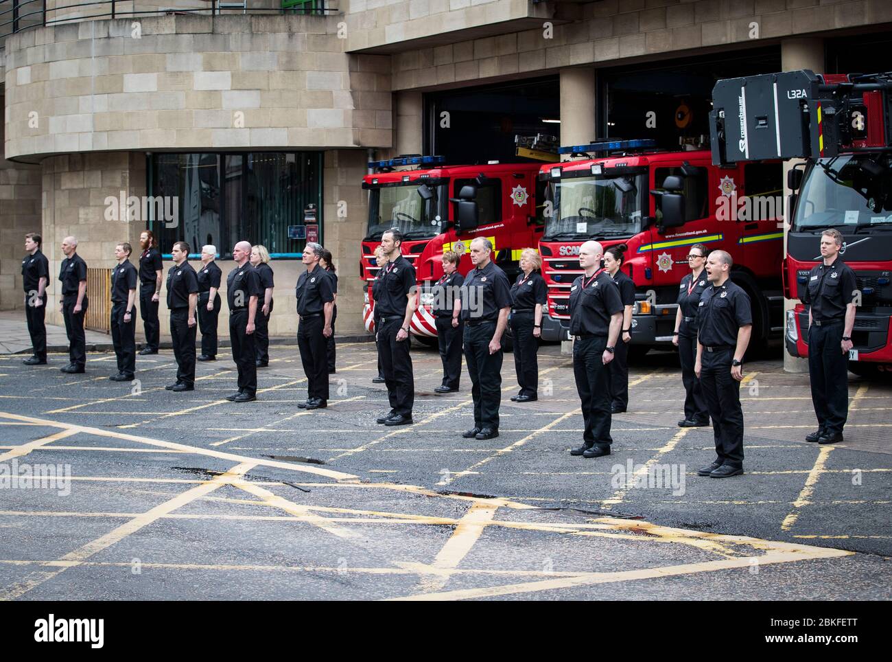 Il personale della stazione e dell'orologio verde della Tollcross Community Fire Station di Edimburgo osserva un minuto di silenzio in memoria dei colleghi che hanno perso la vita nel campo di attività. Foto Stock