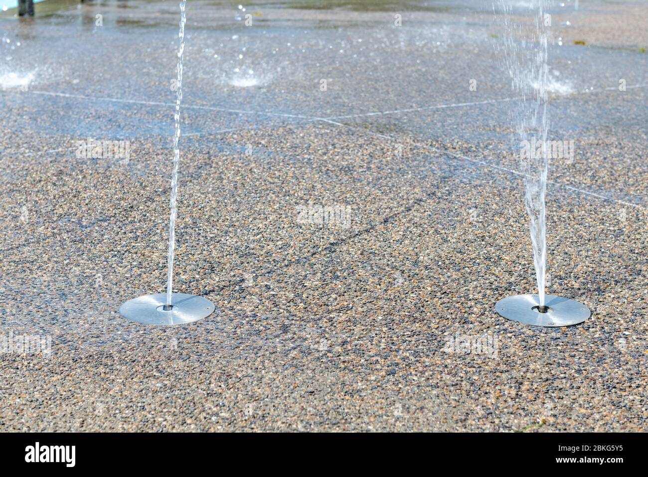 Getti d'acqua sul marciapiede di una città Foto Stock