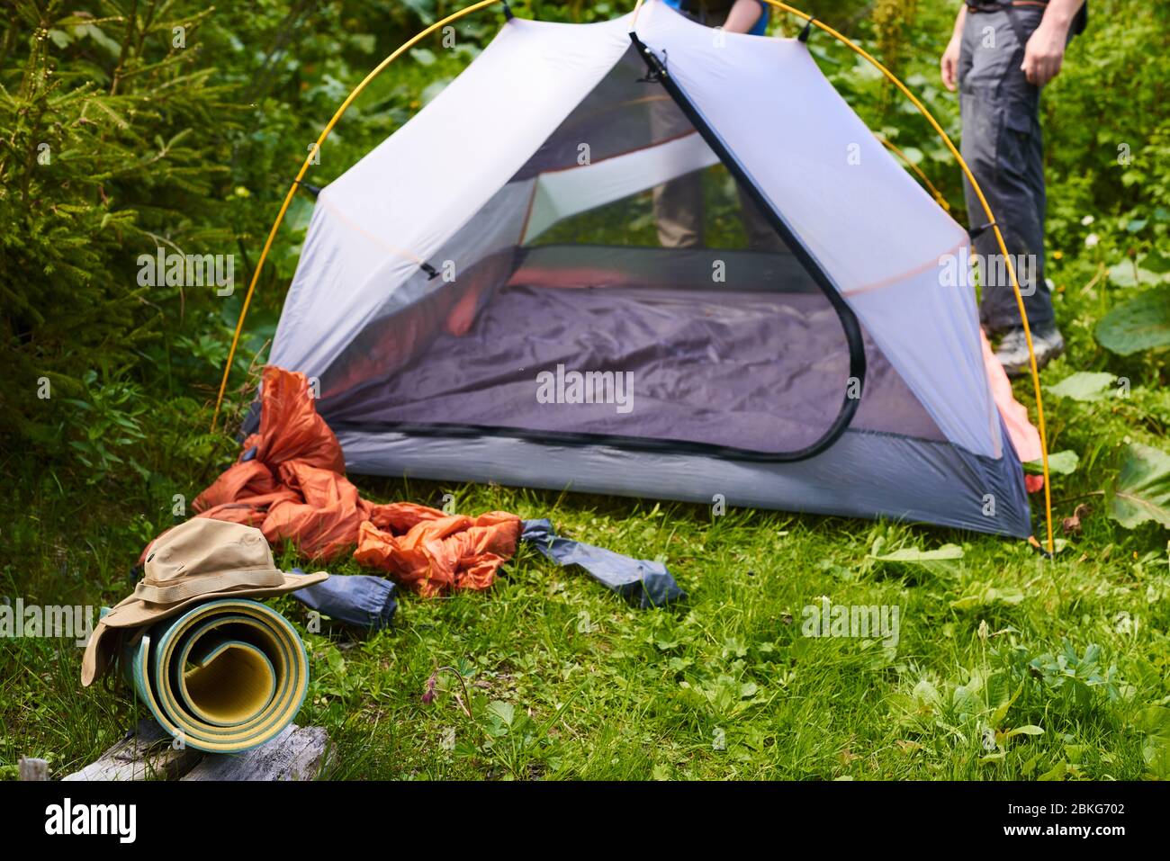 giornata del turismo. Campeggio in tenda - turisti che fissa una tenda sul  campeggio. Primo piano mani uomo tenere una tenda mentre si imposta una  tenda nella foresta Foto stock - Alamy