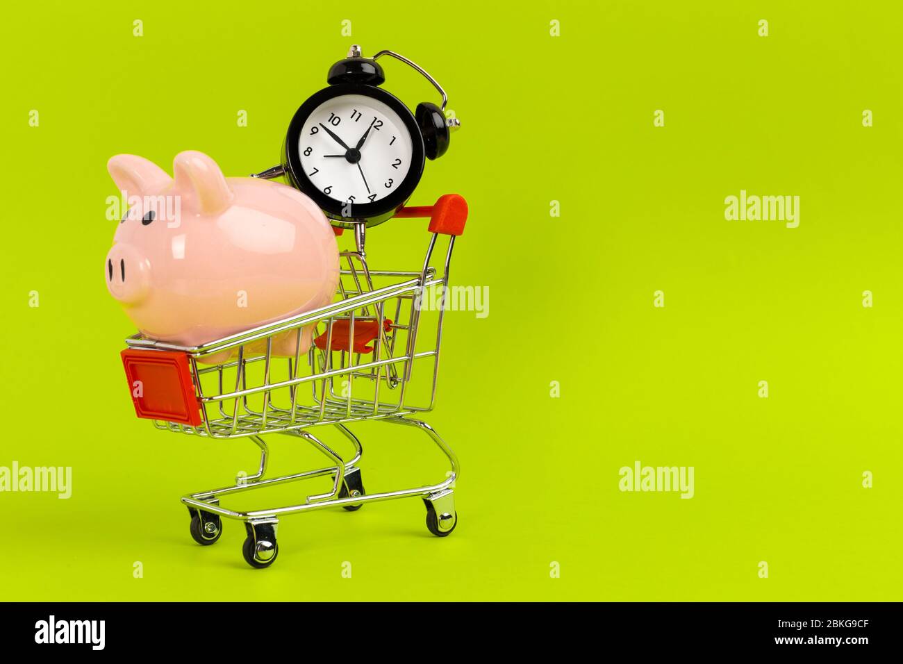 Piccolo carrello con sveglia. Concetto di tempo di shopping Foto Stock