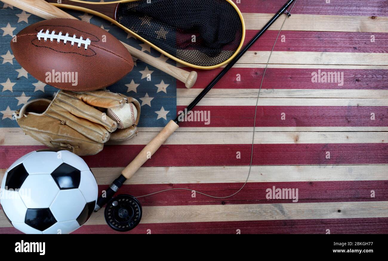 Varie attrezzature sportive per baseball, calcio, calcio e pesca sulla bandiera degli Stati Uniti d'epoca in legno Foto Stock
