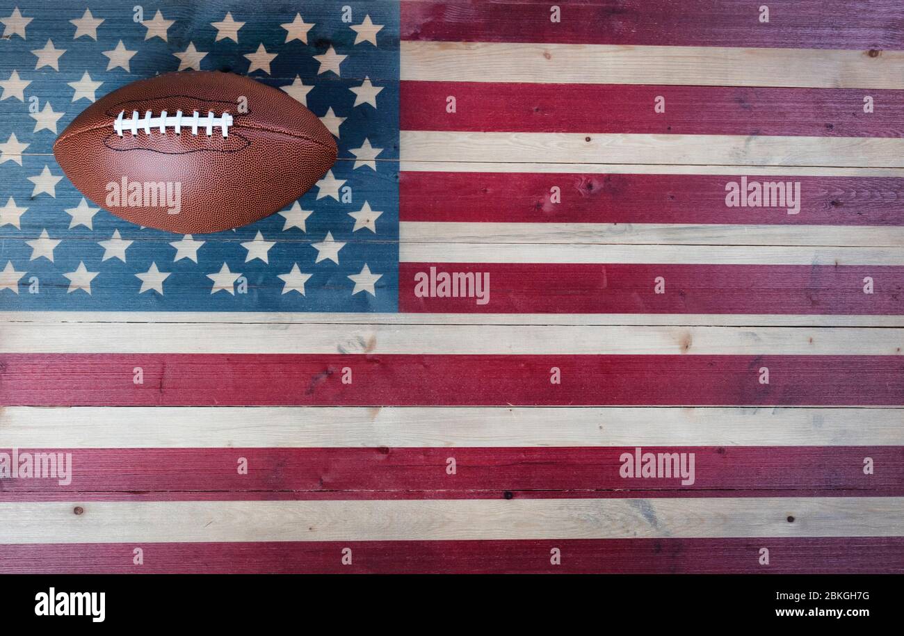 Attrezzature da calcio americane su sfondo di legno d'epoca della bandiera degli Stati Uniti. Concetto sportivo USA con spazio per la copia Foto Stock
