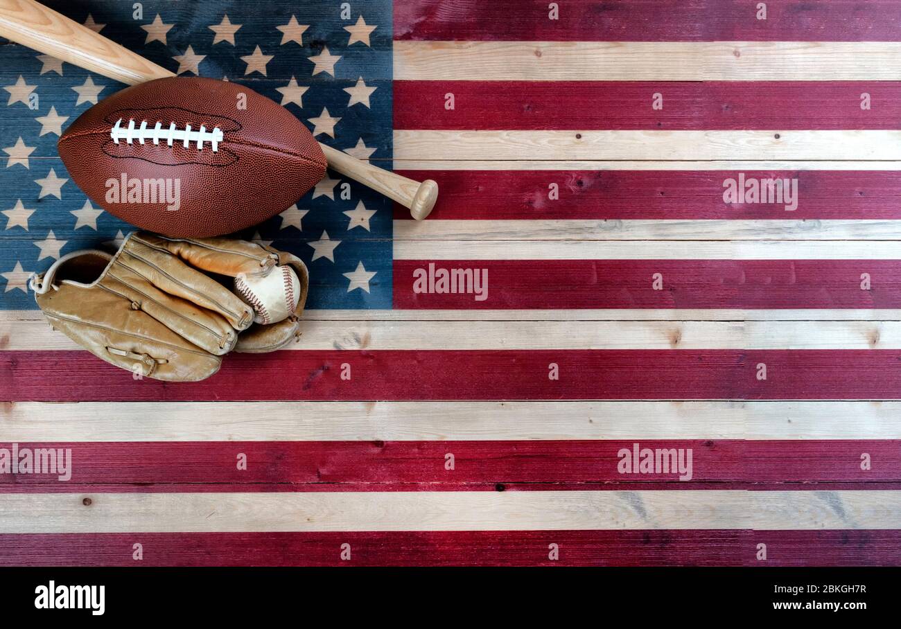Attrezzature da baseball e calcio americane su sfondo di legno d'epoca della bandiera degli Stati Uniti. Concetto sportivo USA con spazio per la copia Foto Stock