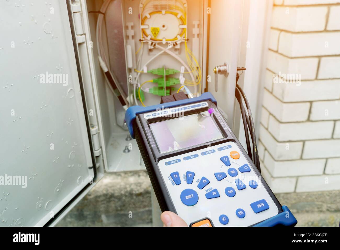 Il tecnico misura il livello del segnale ottico. Un tecnico diagnostica un'area problematica in una rete di telecomunicazioni. Foto Stock