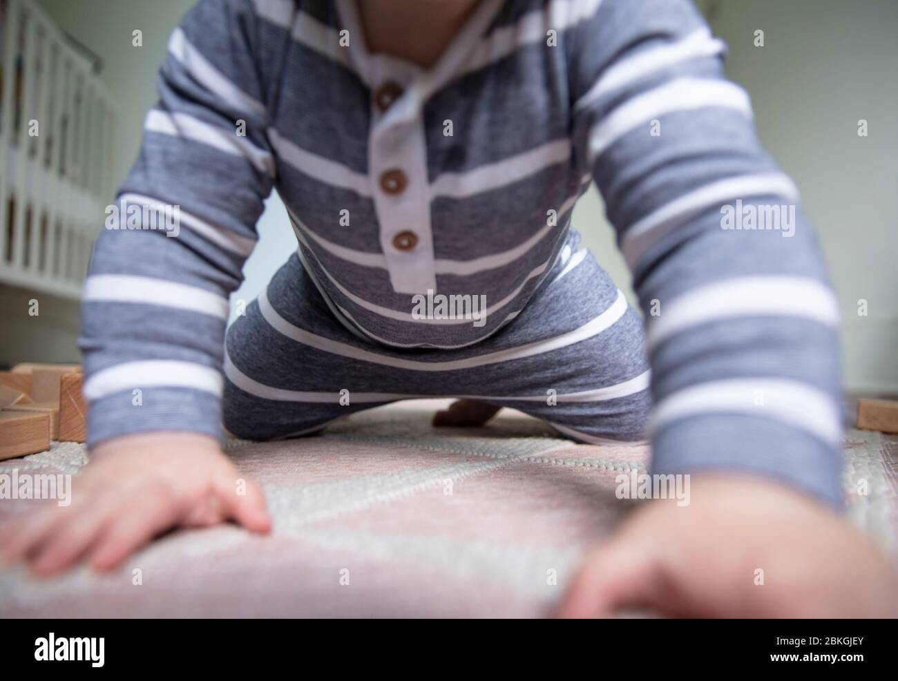 Primo piano di un bambino mentre cerca di strisciare verso la fotocamera Foto Stock