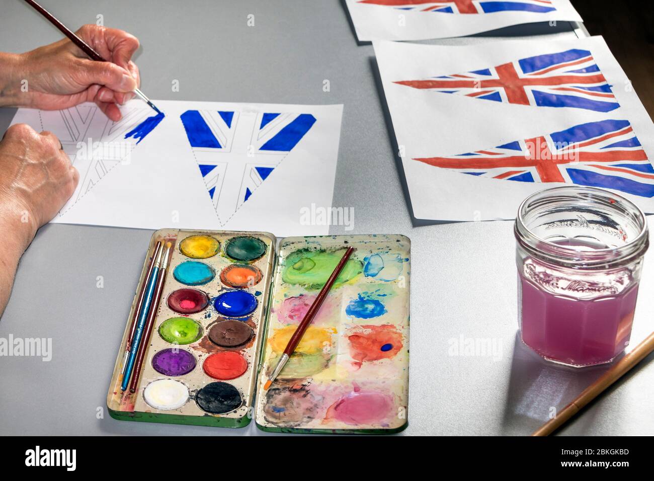 Woman Painting 75th Anniversary VE Day Flags, UK Foto Stock