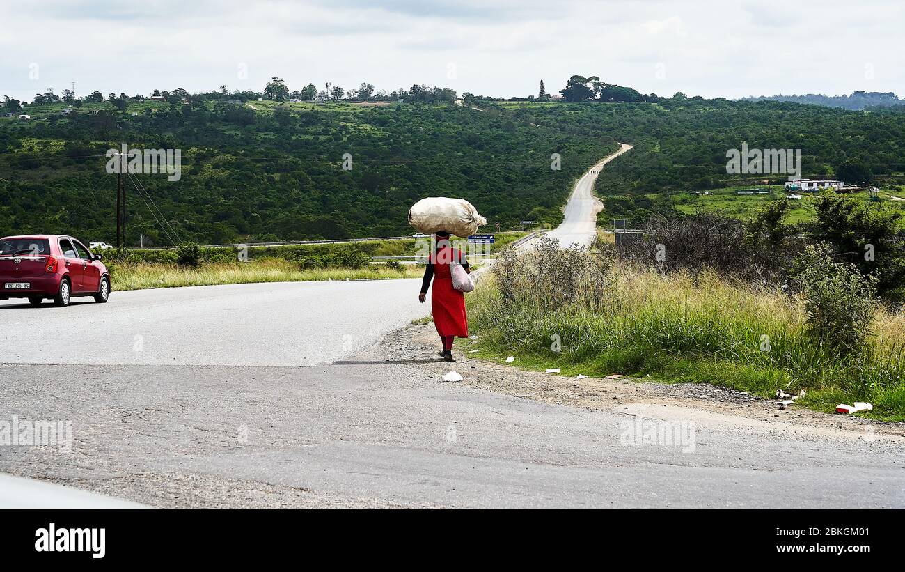 Le donne trasportano la borsa sopra la sua testa Foto Stock
