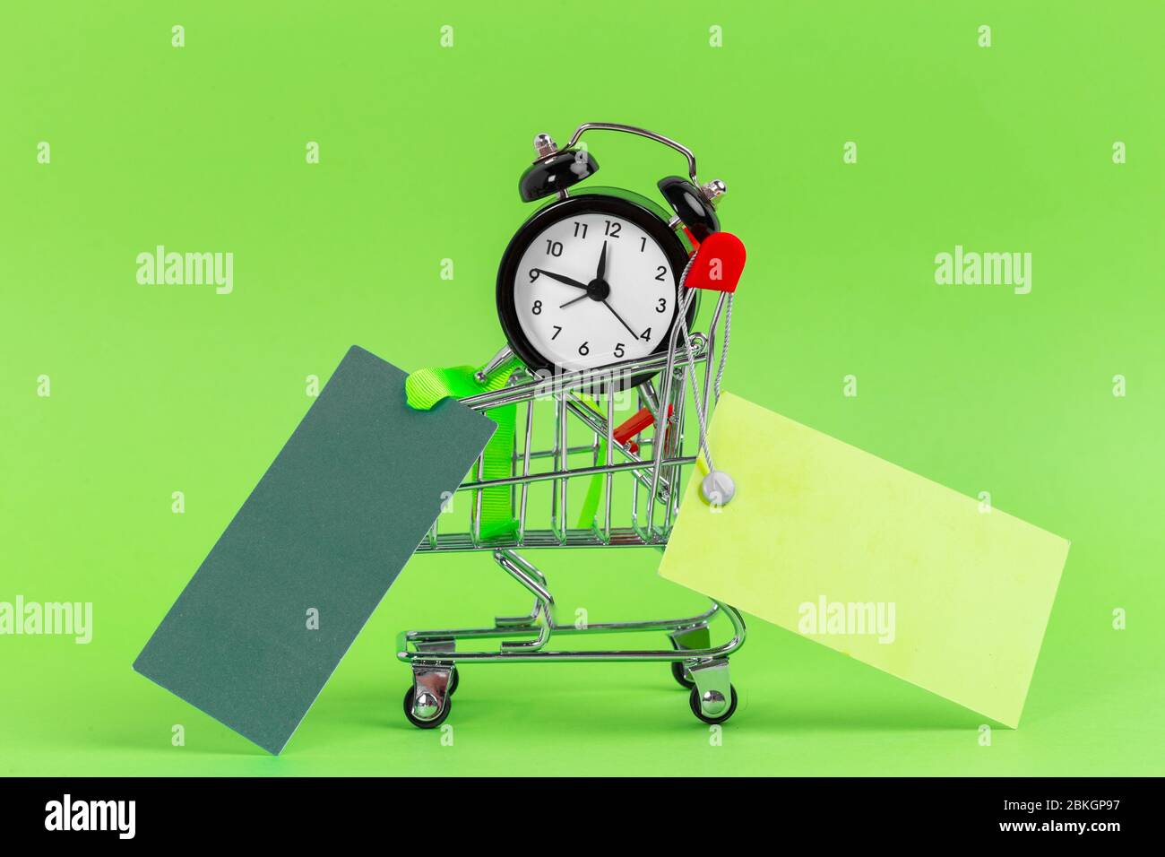 Piccolo carrello con sveglia. Concetto di tempo di shopping. Primo piano. Foto Stock