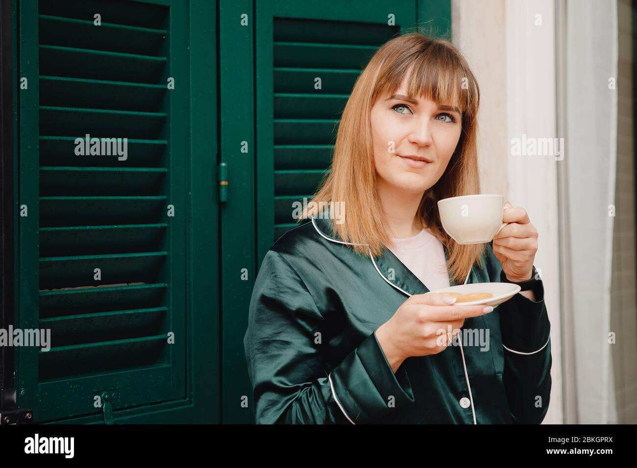 Il buon giorno, la ragazza beve il caffè da una tazza bianca. Foto Stock