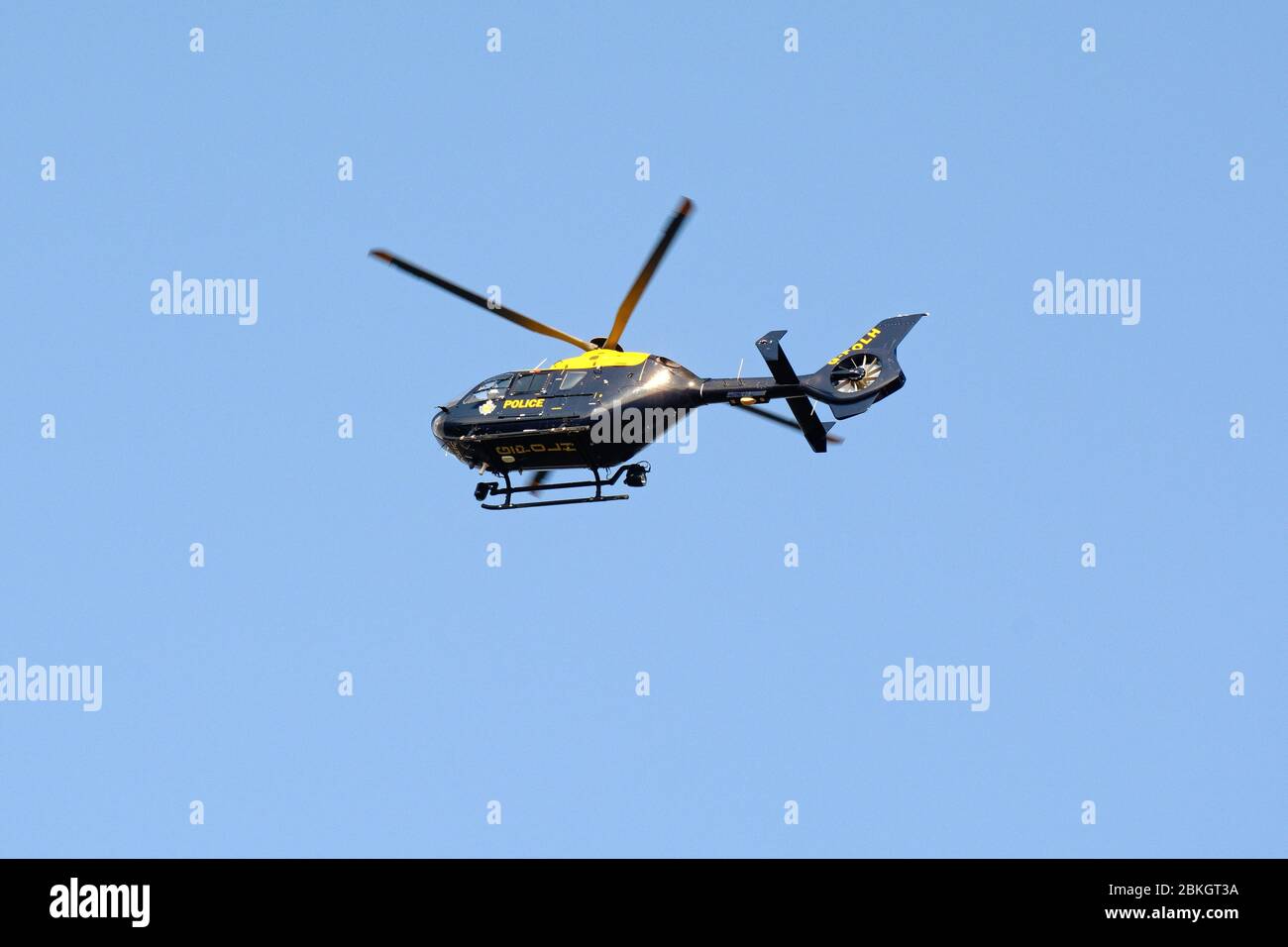 Un elicottero della polizia Nazionale che si sorvola sopra contro un cielo blu chiaro Foto Stock