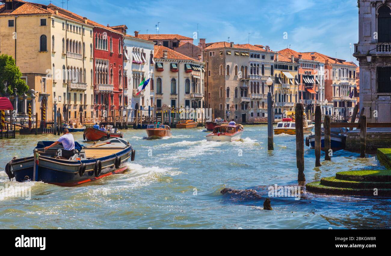 Venezia, Provincia di Venezia, Regione Veneto, Italia. Traffico sul Canal Grande. Barche di consegna. Taxi acquatici. Venezia è un sito patrimonio dell'umanità dell'UNESCO. Foto Stock